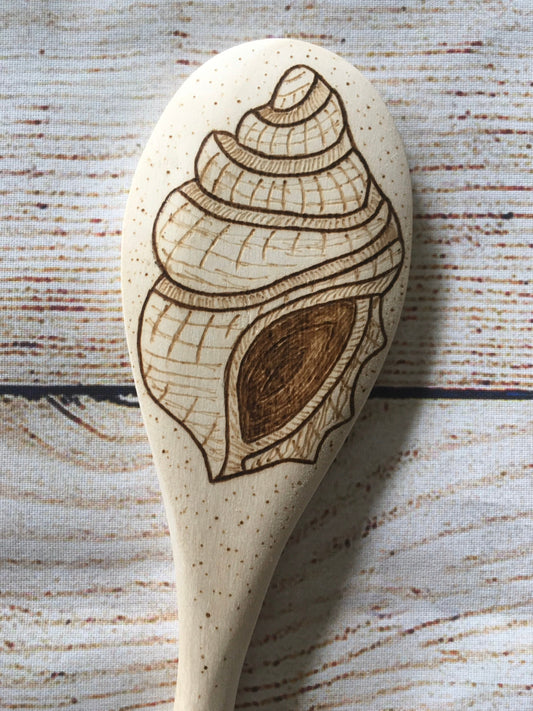 wood burned wooden spoon with a seashell burned on the back of the spoon