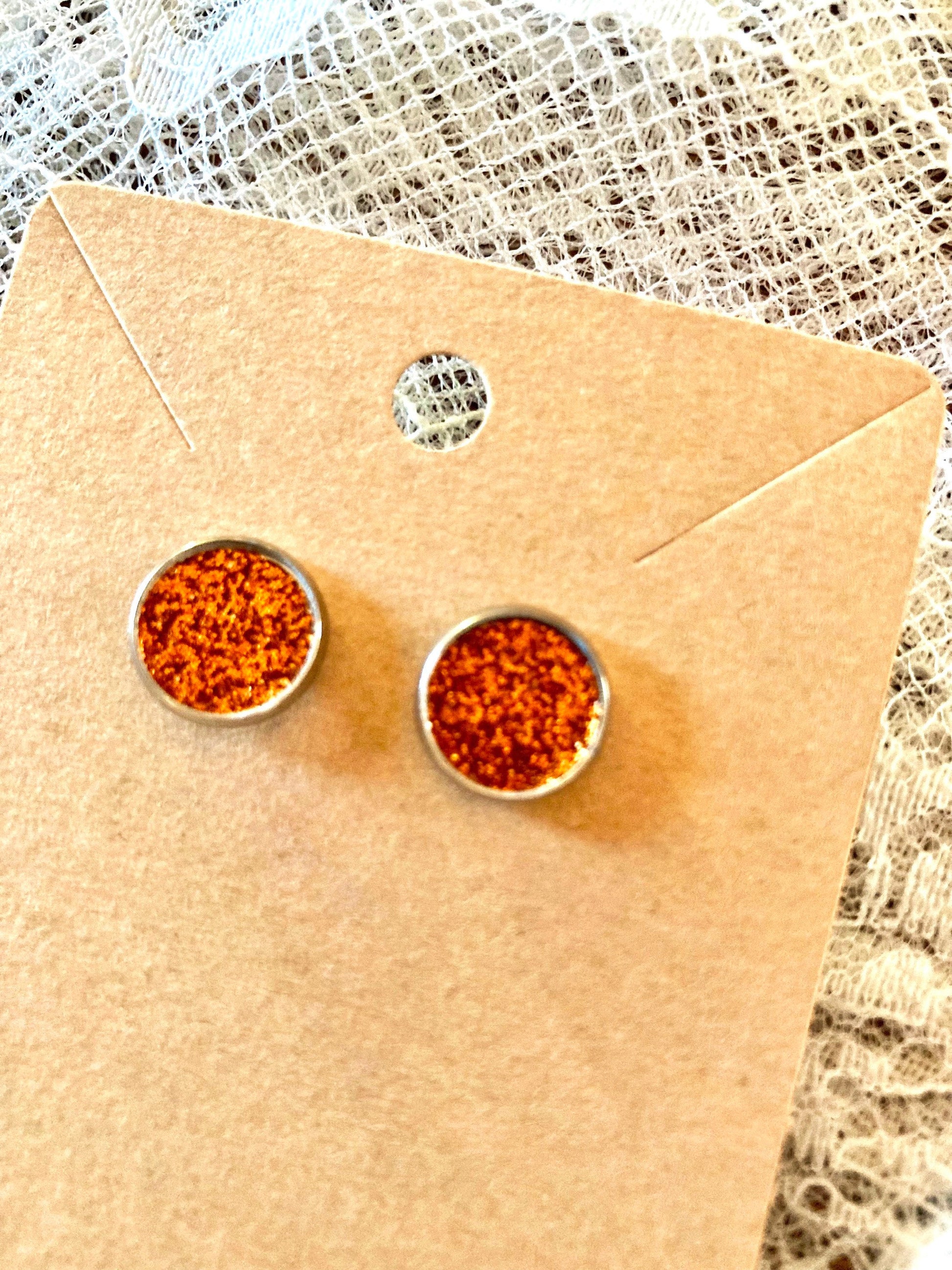 round stud earrings with a glittery orange faux leather center