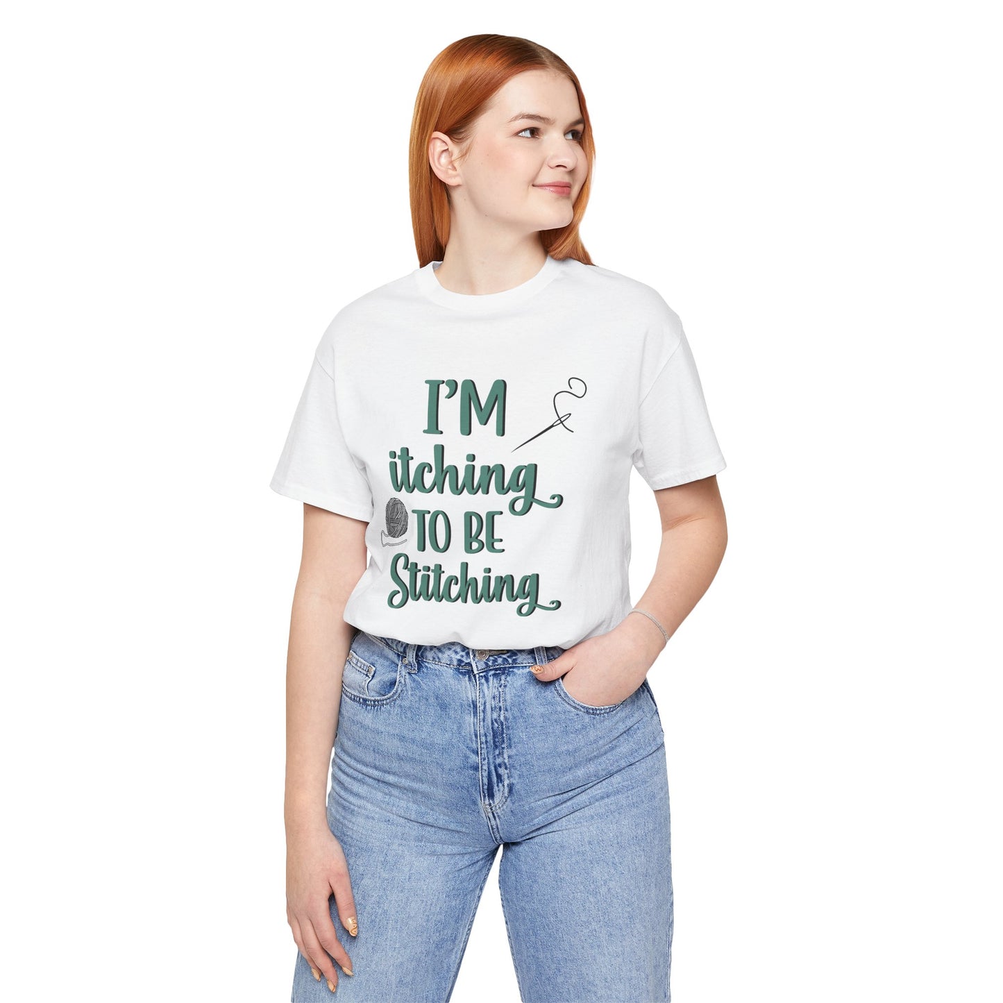 Funny Itching to be Stitching white colored T-Shirt with heather teal lettering, a ball of yarn, and a needle with thread worn by a woman