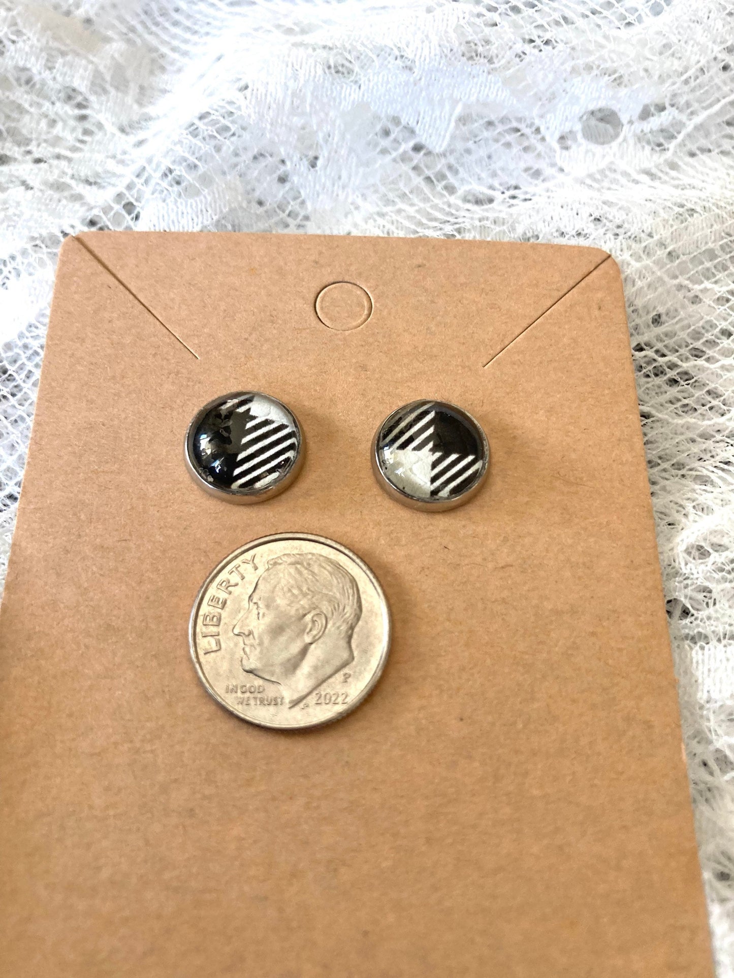 round stud earrings with a black and white buffalo plaid faux leather center with a dime to show size