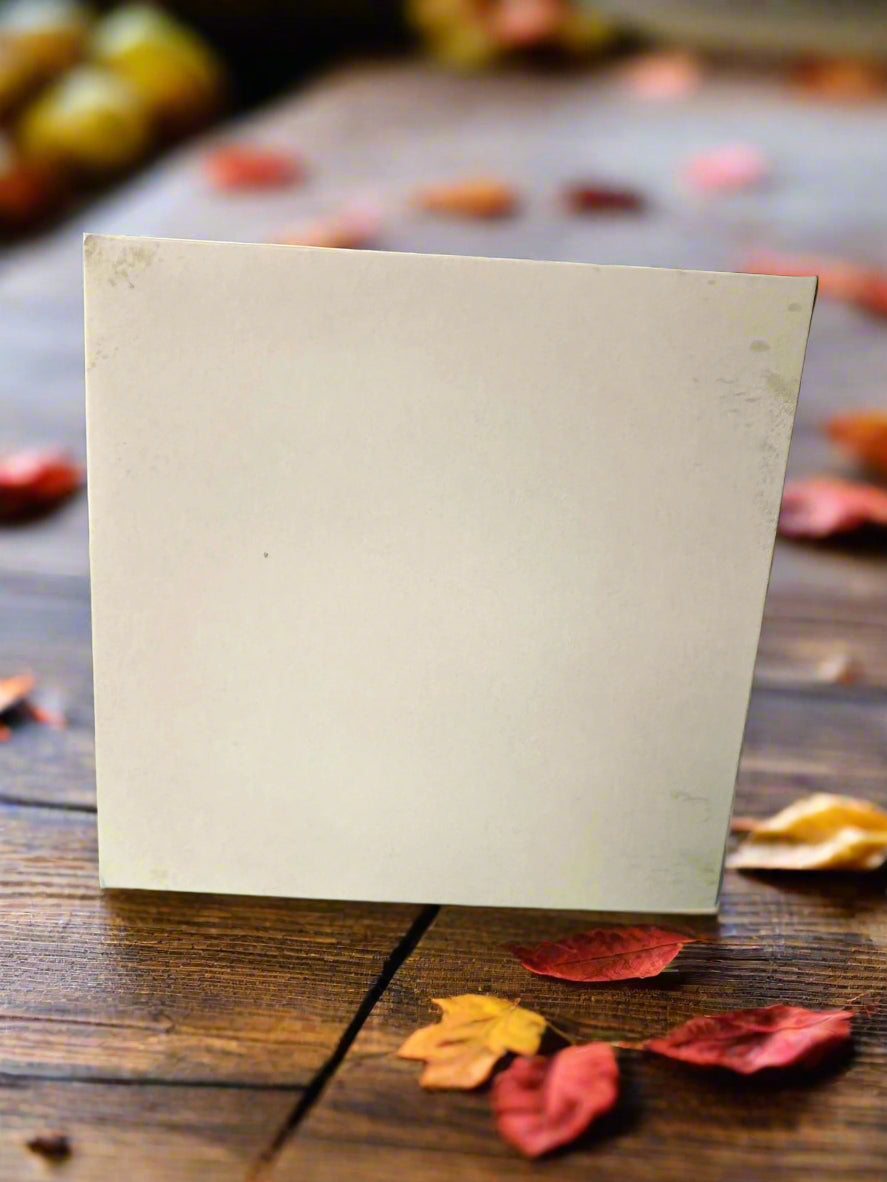 Blank white back of card on a wooden surface with autumn leaves