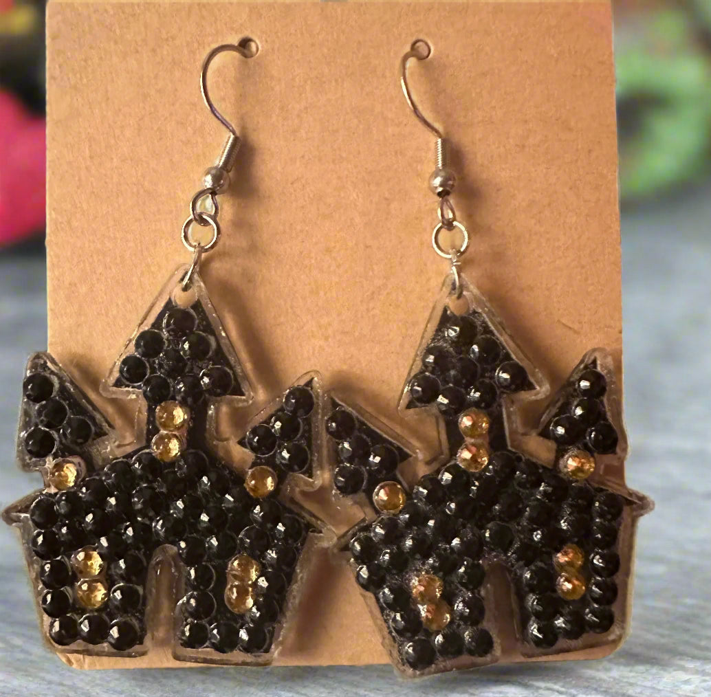 Halloween-themed earrings on a brown card with a blurred background