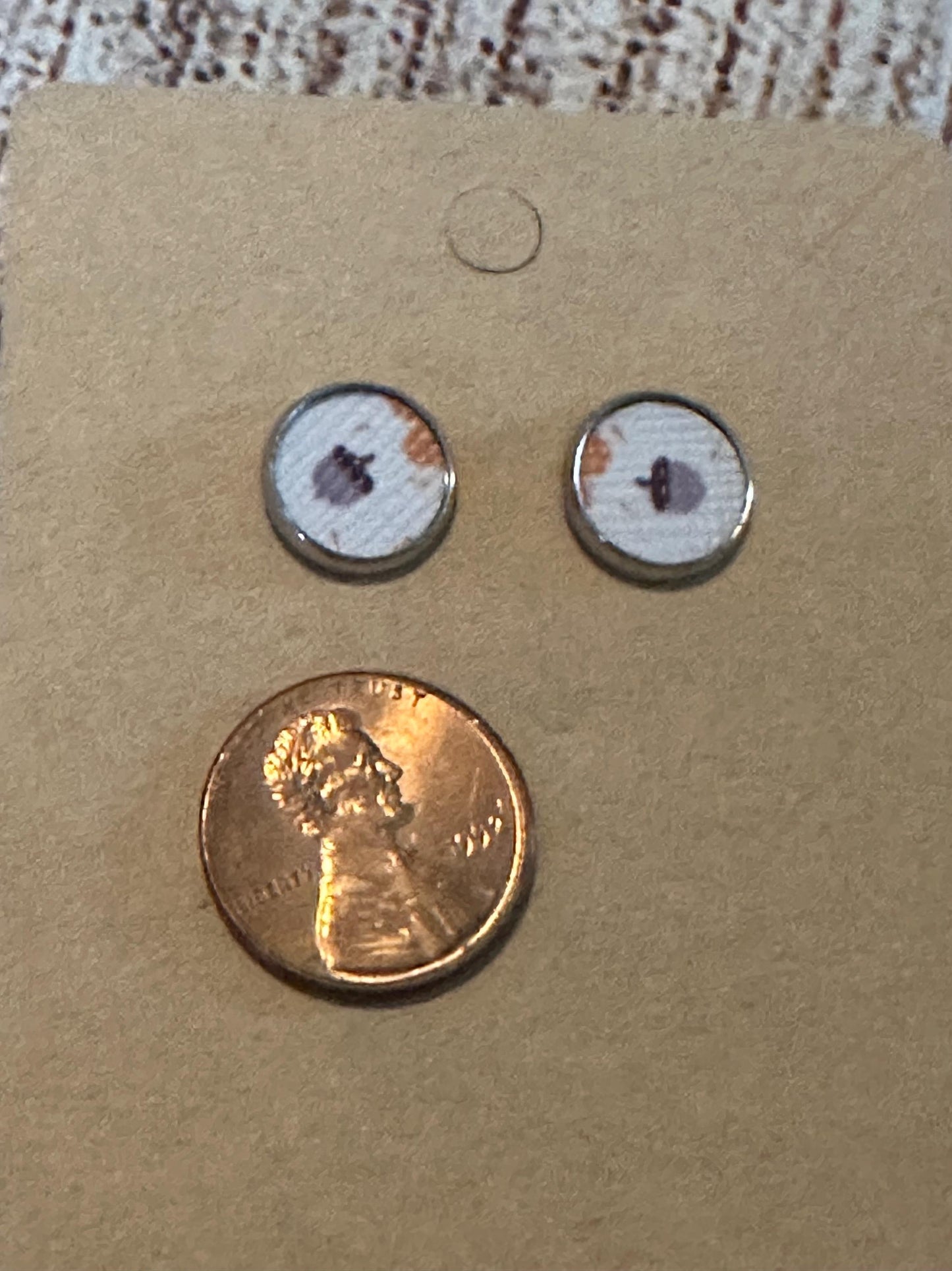 round stud earrings with an acorn faux leather center with penny to show size