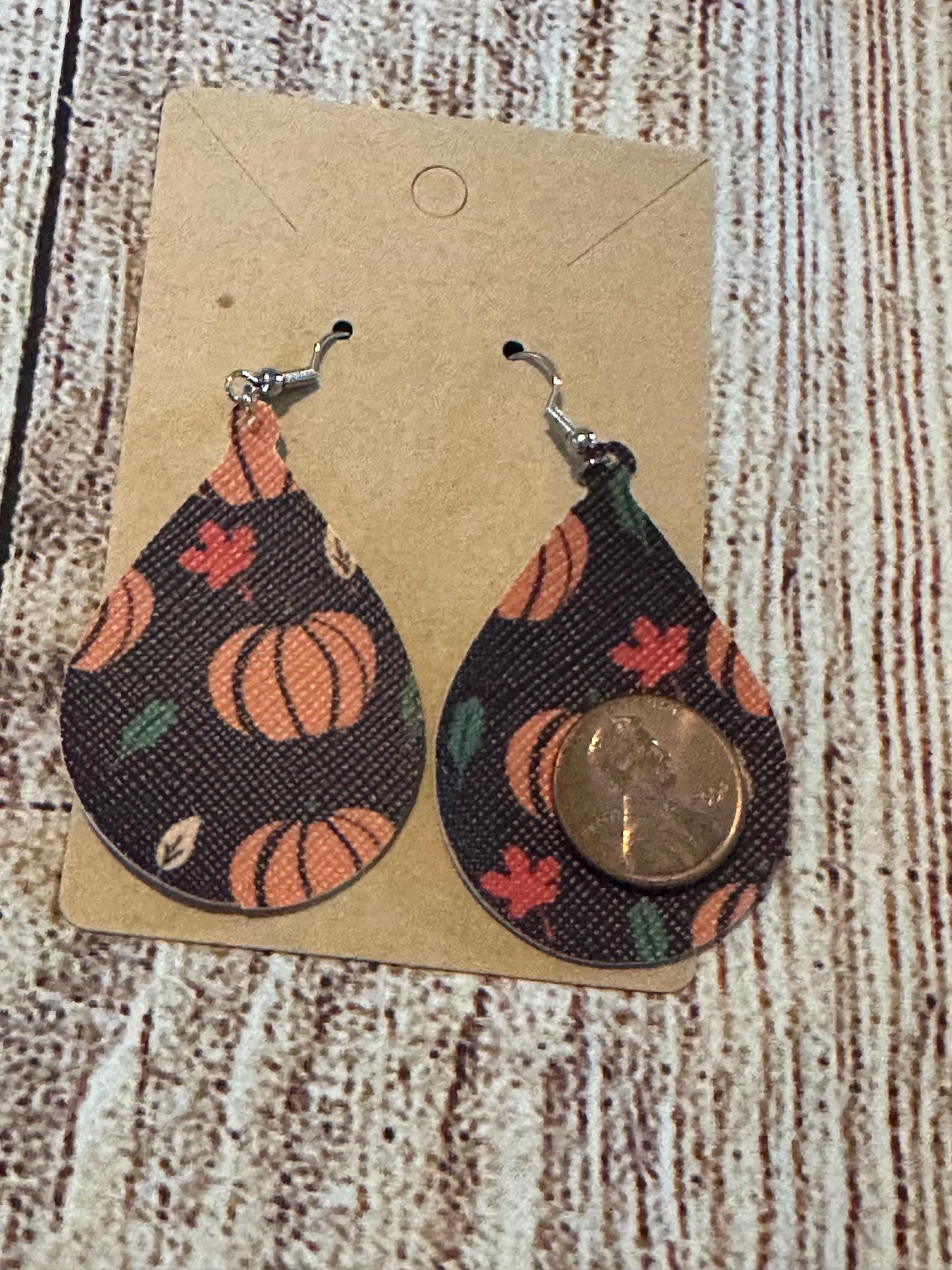 Pumpkin Faux Leather Teardrop Earrings- orange pumpkins, fall colored leaves on brown background with penny for size