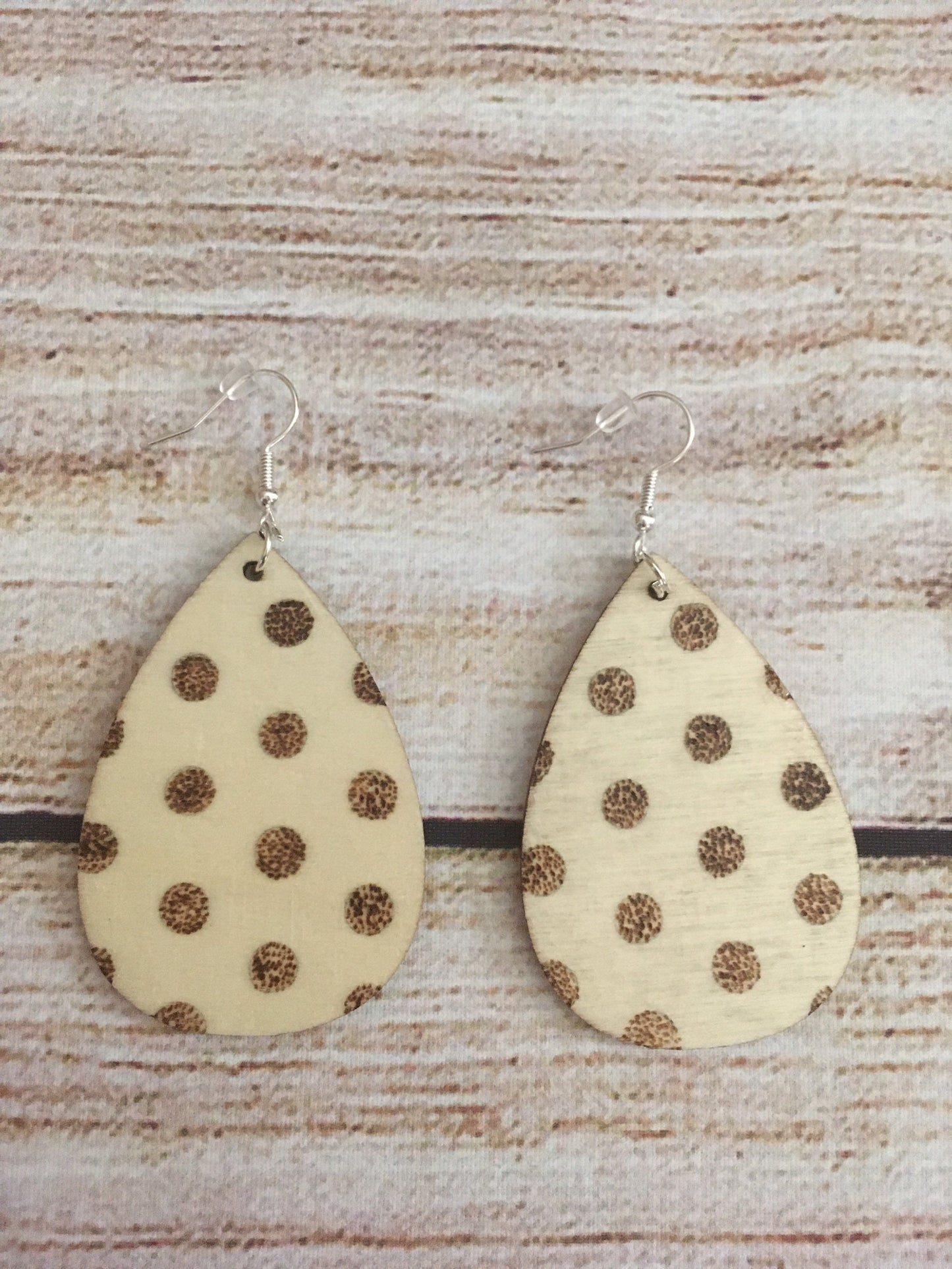 Wood burned earring with polka dot pattern. Earrings are tear drop shaped with fishhooks