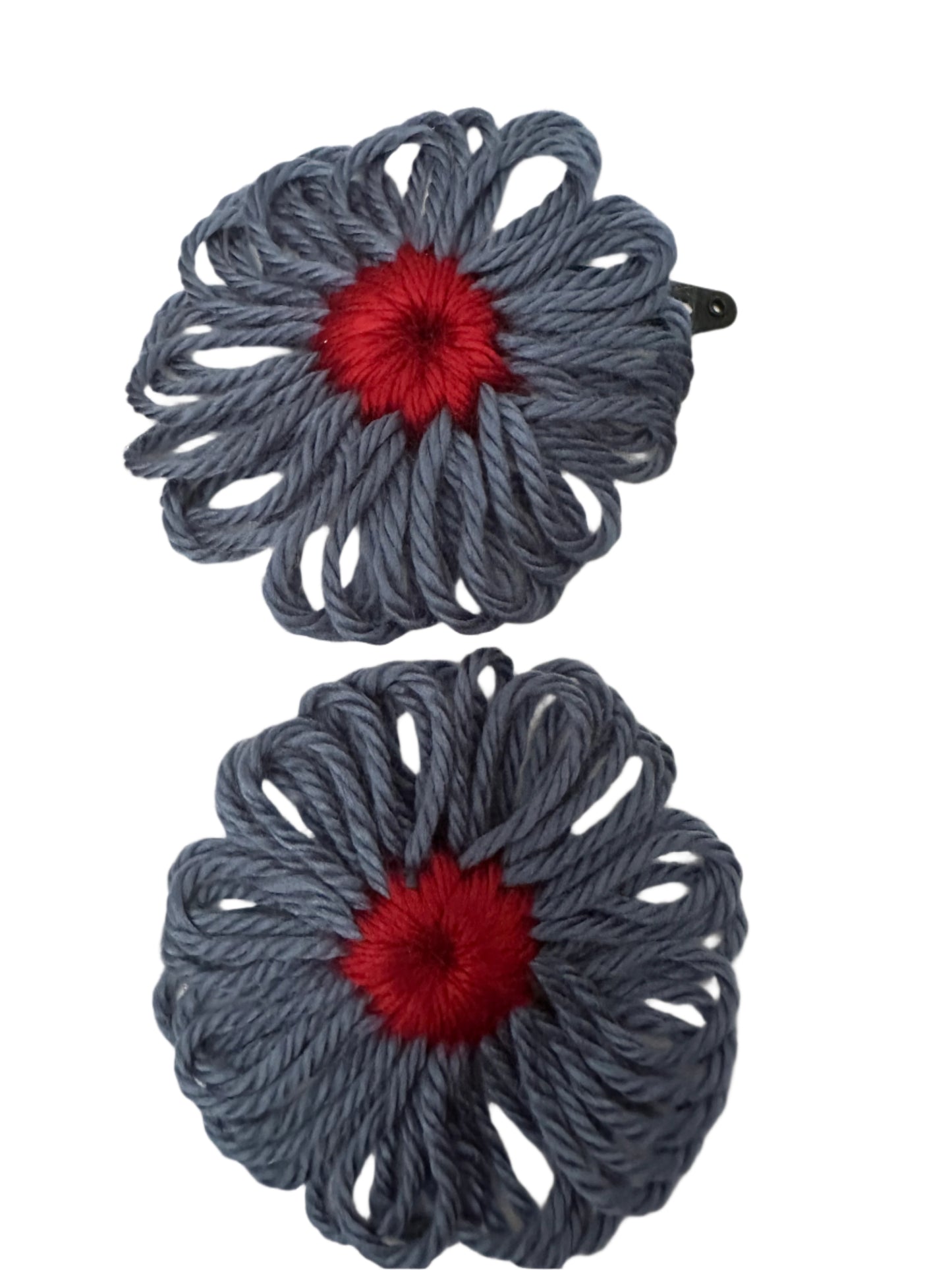 Two country blue yarn flower hair clips with red centers on a white background.