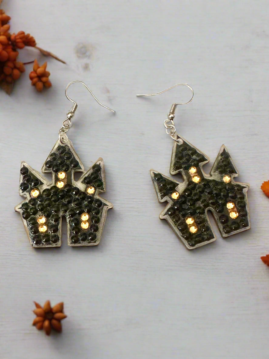 Halloween-themed castle earrings on a light gray background