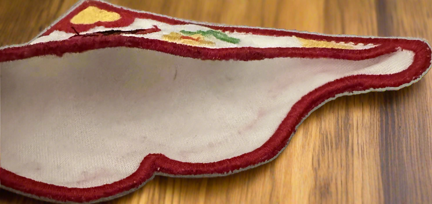 Fabric corner bookmark inside with embroidered design on a wooden surface