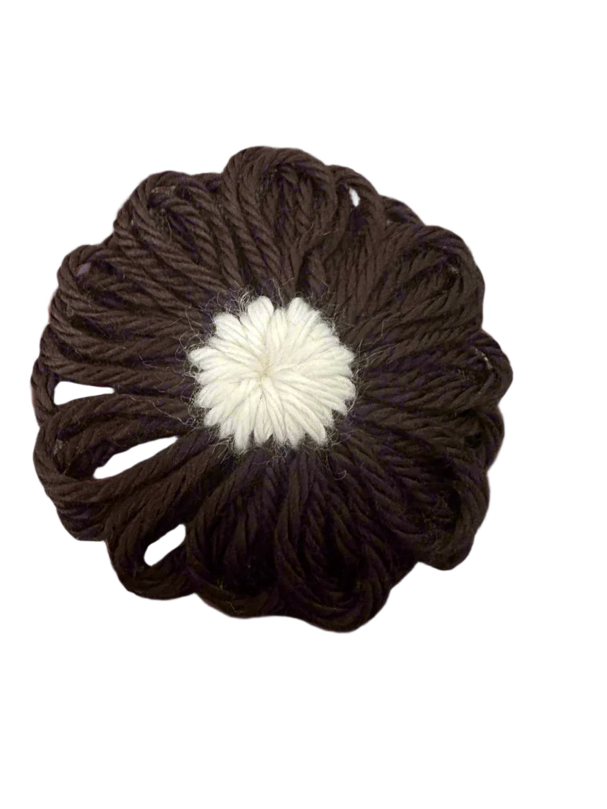 black with white center yarn flowers snap clip with white centers on a gray surface