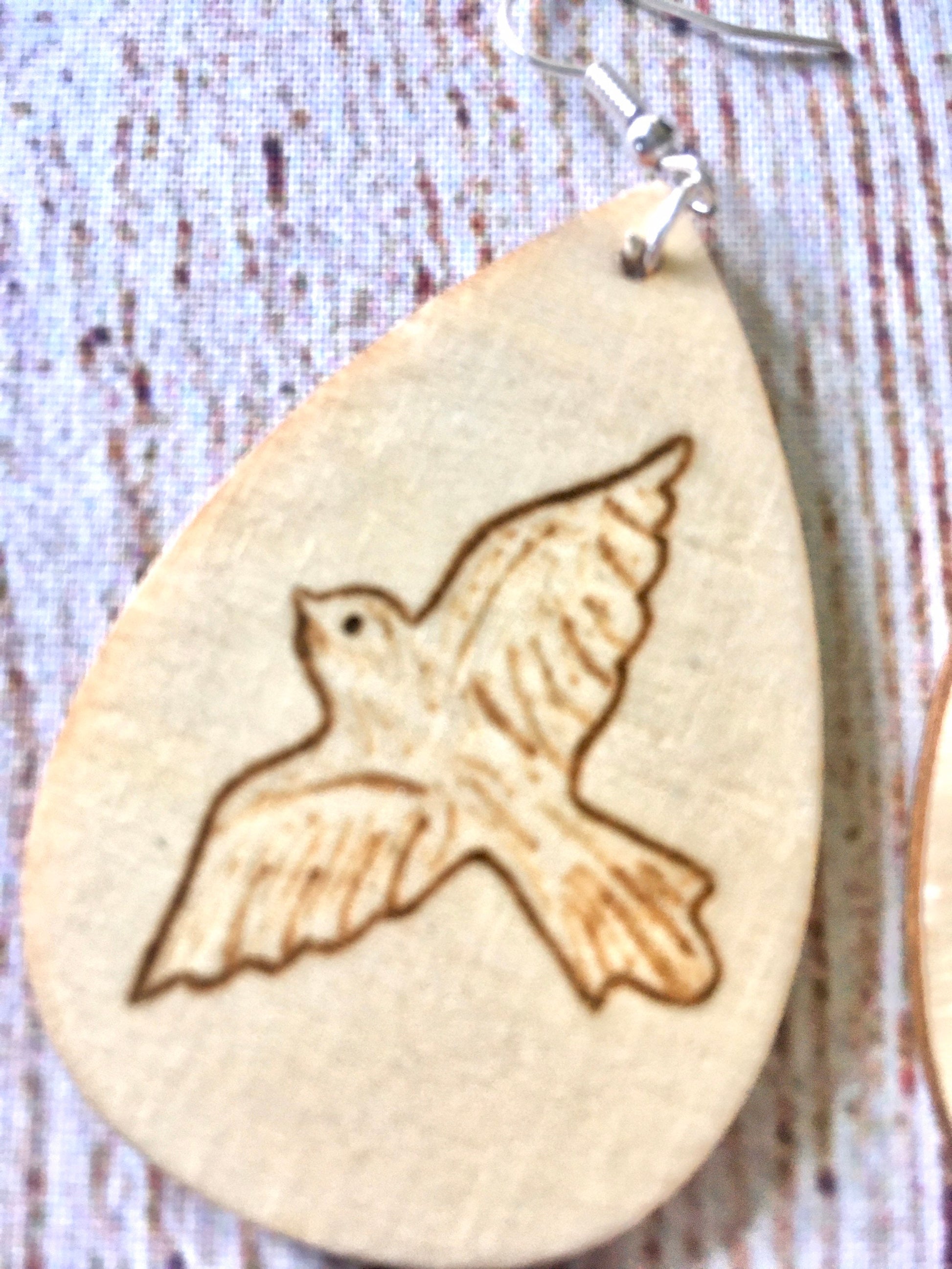 Wood burned earrings with dove bird  flying. Earrings are tear drop shaped with fishhooks.
