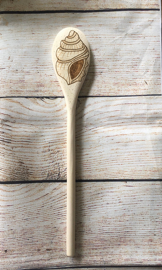 wood burned wooden spoon with a seashell burned on the back of the spoon