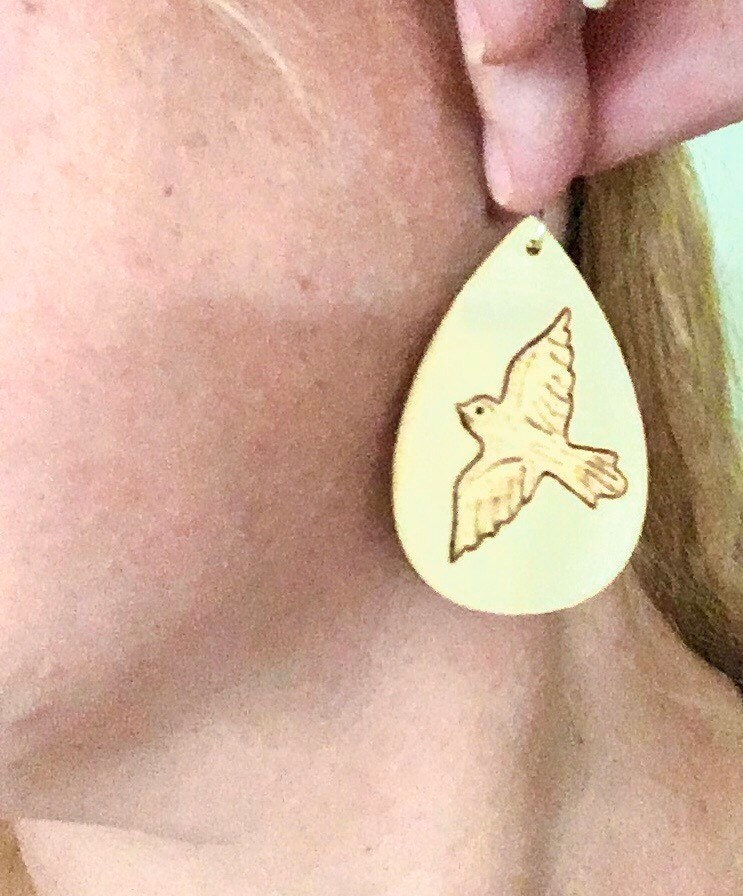 Wood burned earrings with dove bird  flying. Earrings are tear drop shaped with fishhooks.