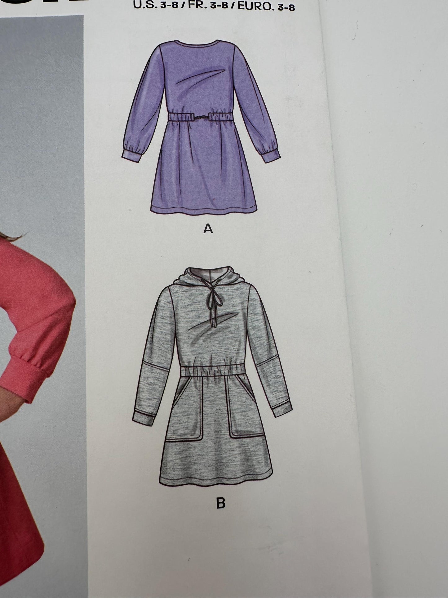 Patterned dress designs on a paper sheet with measurements and color options.