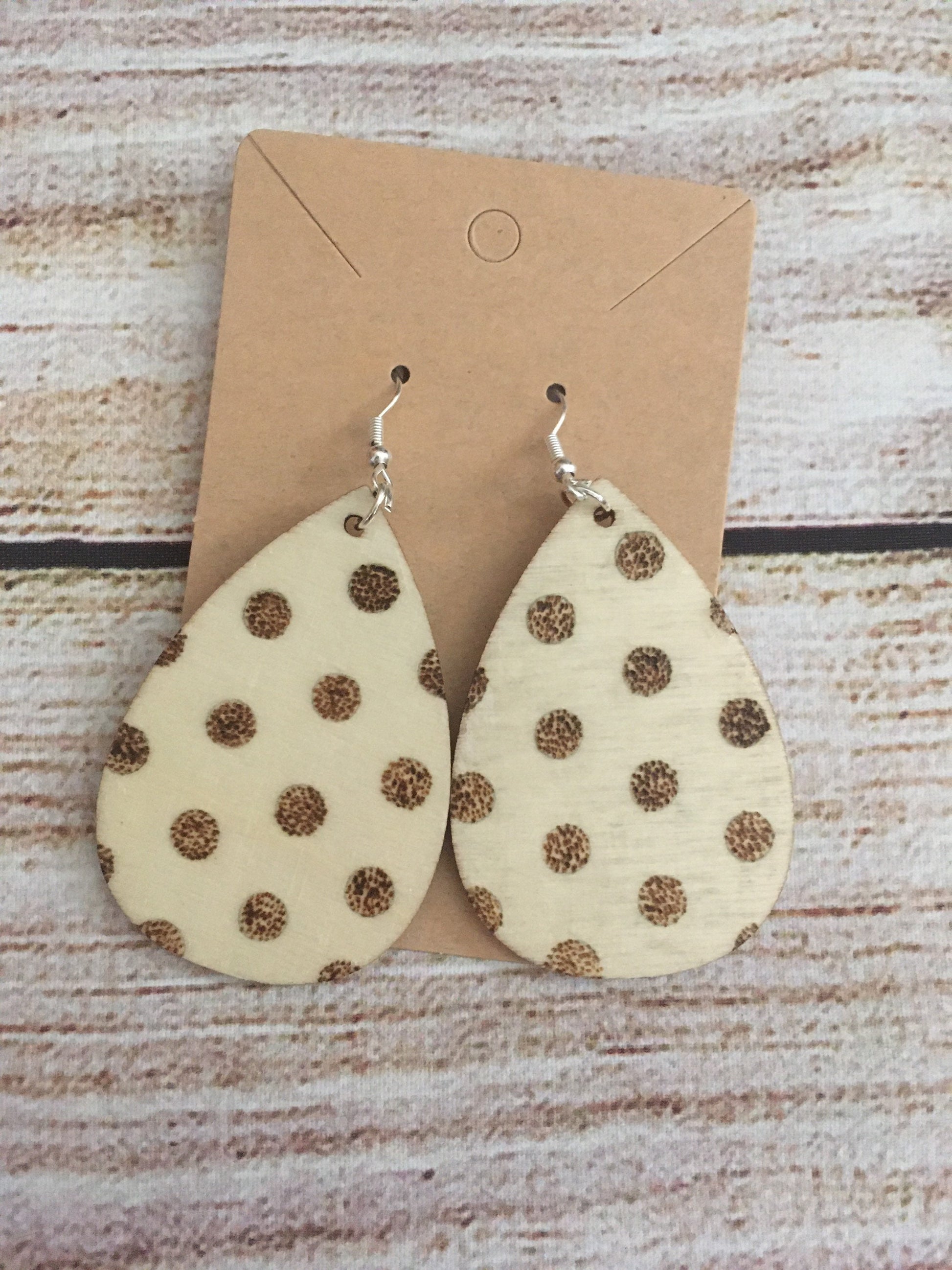Wood burned earring with polka dot pattern. Earrings are tear drop shaped with fishhooks