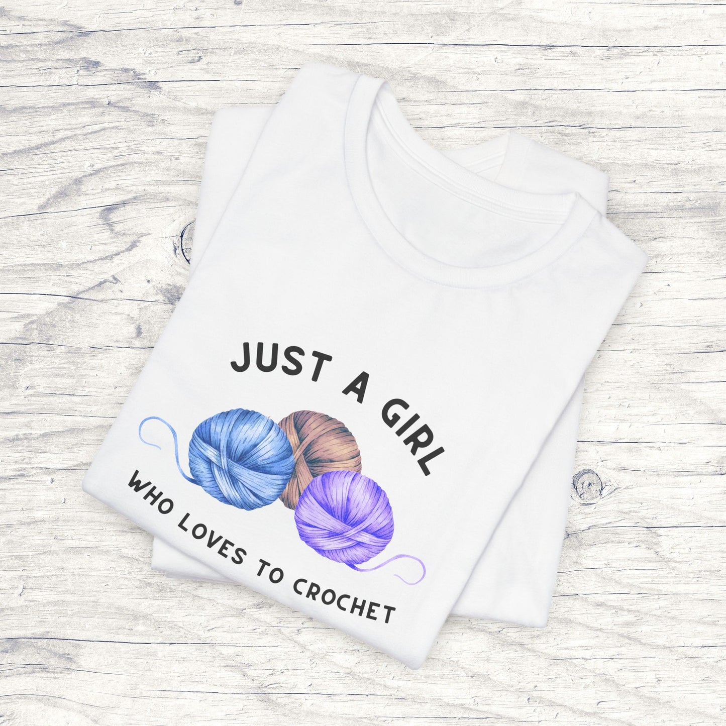 Funny Crochet T-Shirt Just a Girl Who Loves to Crochet Shirt white folded shirt with black letters and three balls of yarn