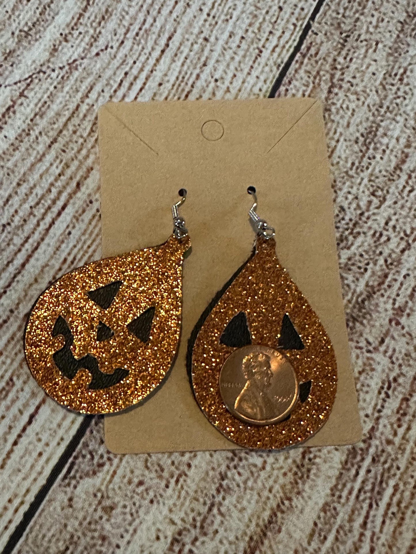 Jack-o-lantern Faux Leather Teardrop Earrings double layer- black under layer with sparkly orange jack o lantern overlay with penny for size
