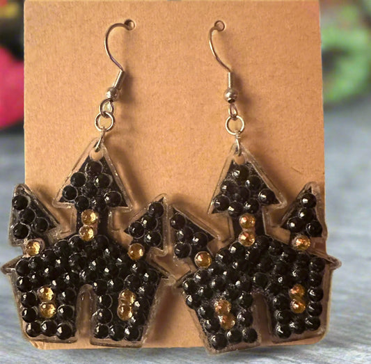 Halloween-themed earrings on a brown card with a blurred background