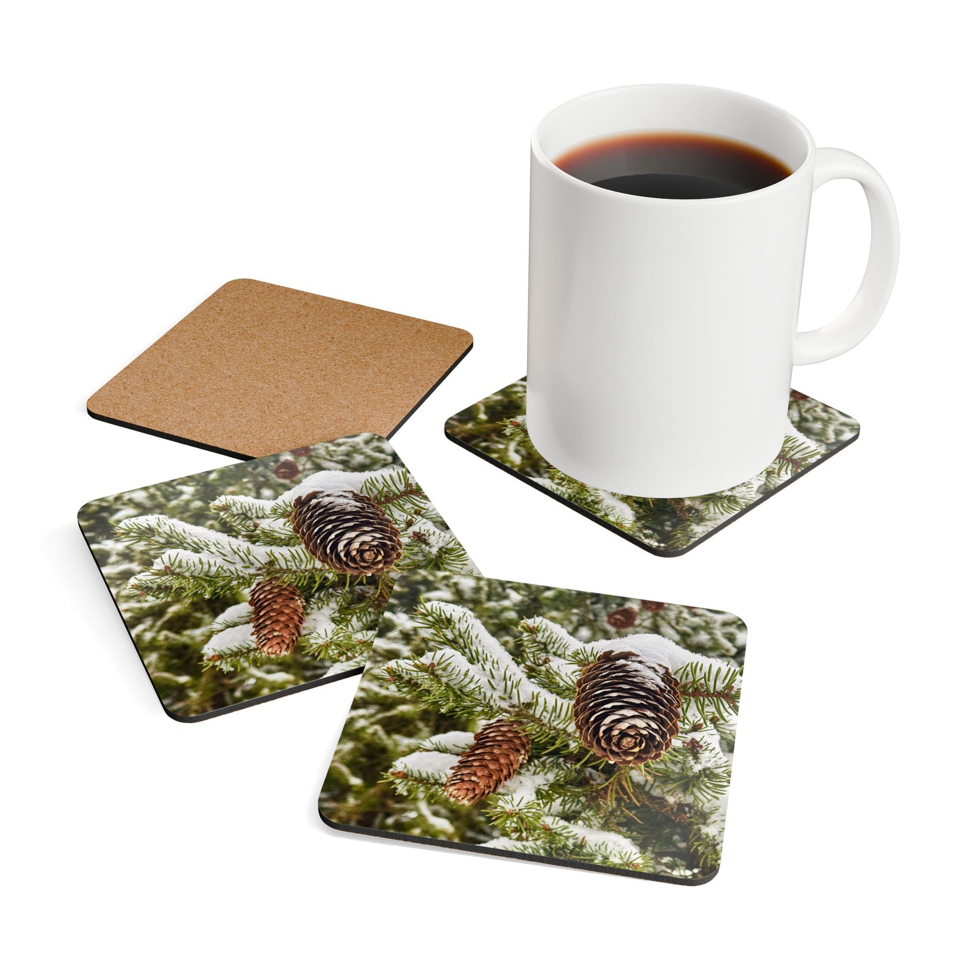 Snowy Pinecone Coasters, one coaster upside down showing cork backing, one has white mug on it.
