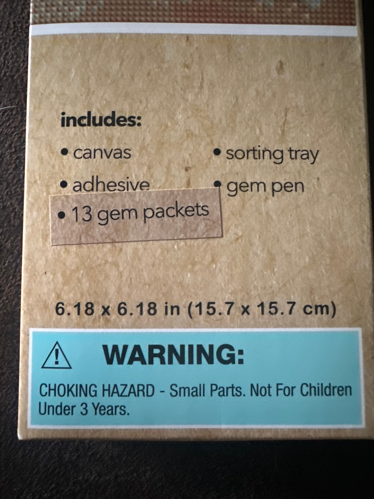 Cardboard box with product details and warning label on a dark surface