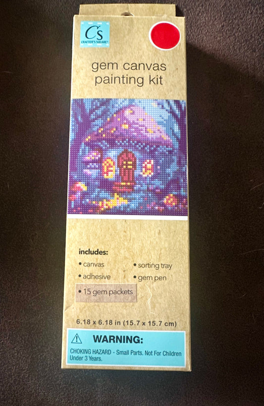 Box of gem canvas painting kit with a colorful mushroom house design on a blue colorful background with trees