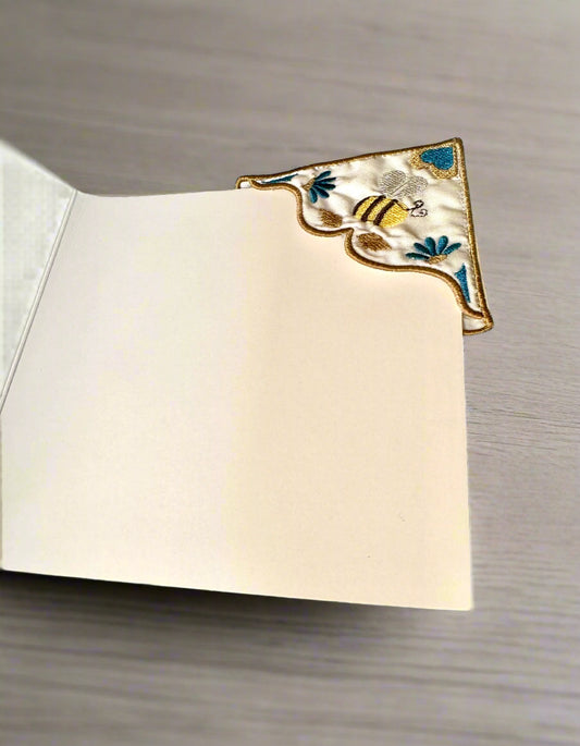 Decorative corner bookmark with bee design on a book