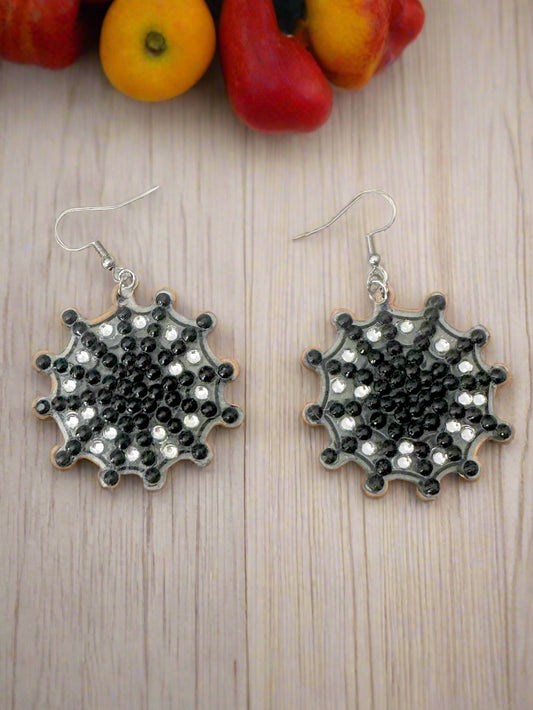 Black and silver cobweb earrings on a wooden surface 