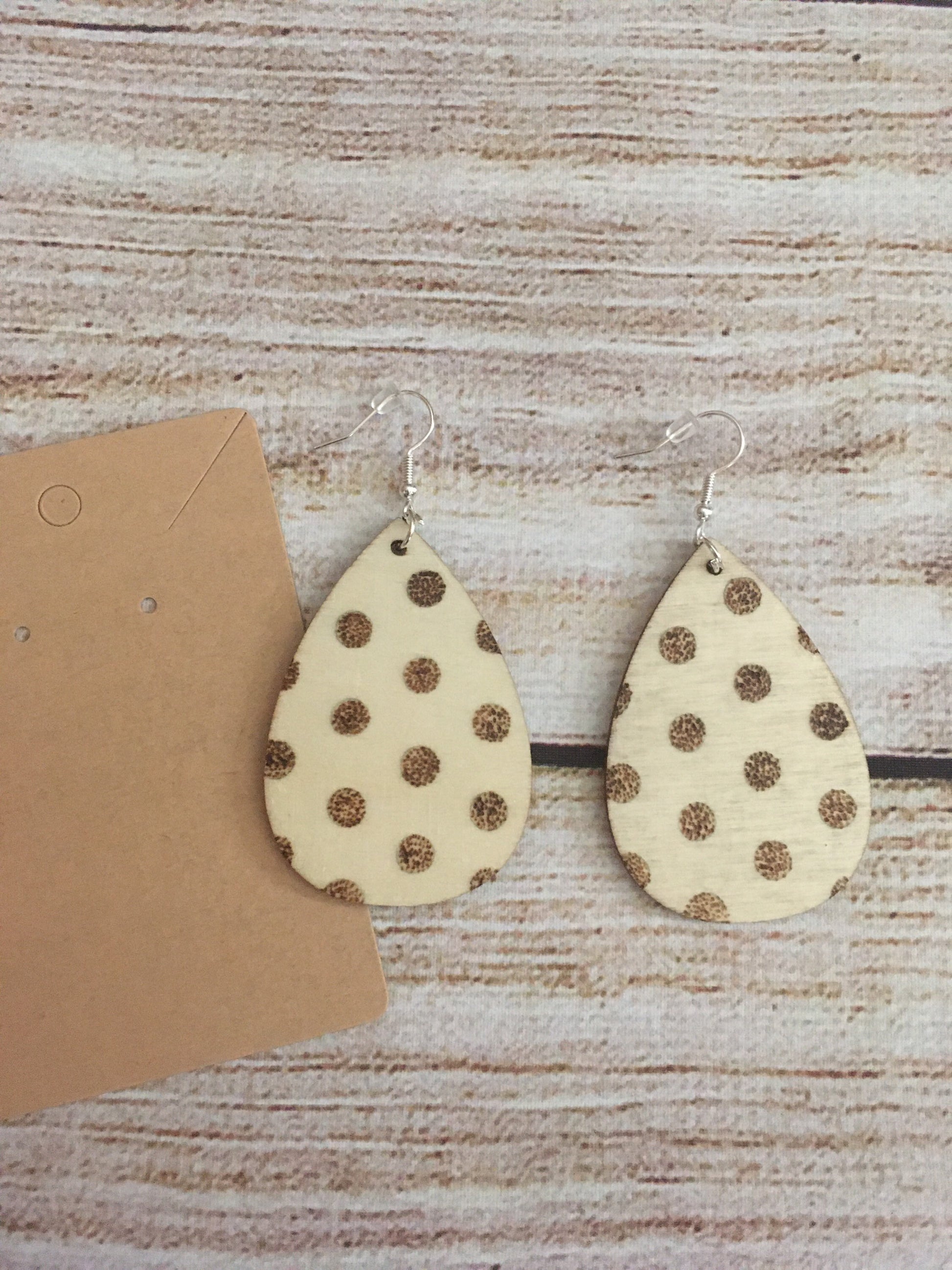 Wood burned earring with polka dot pattern. Earrings are tear drop shaped with fishhooks