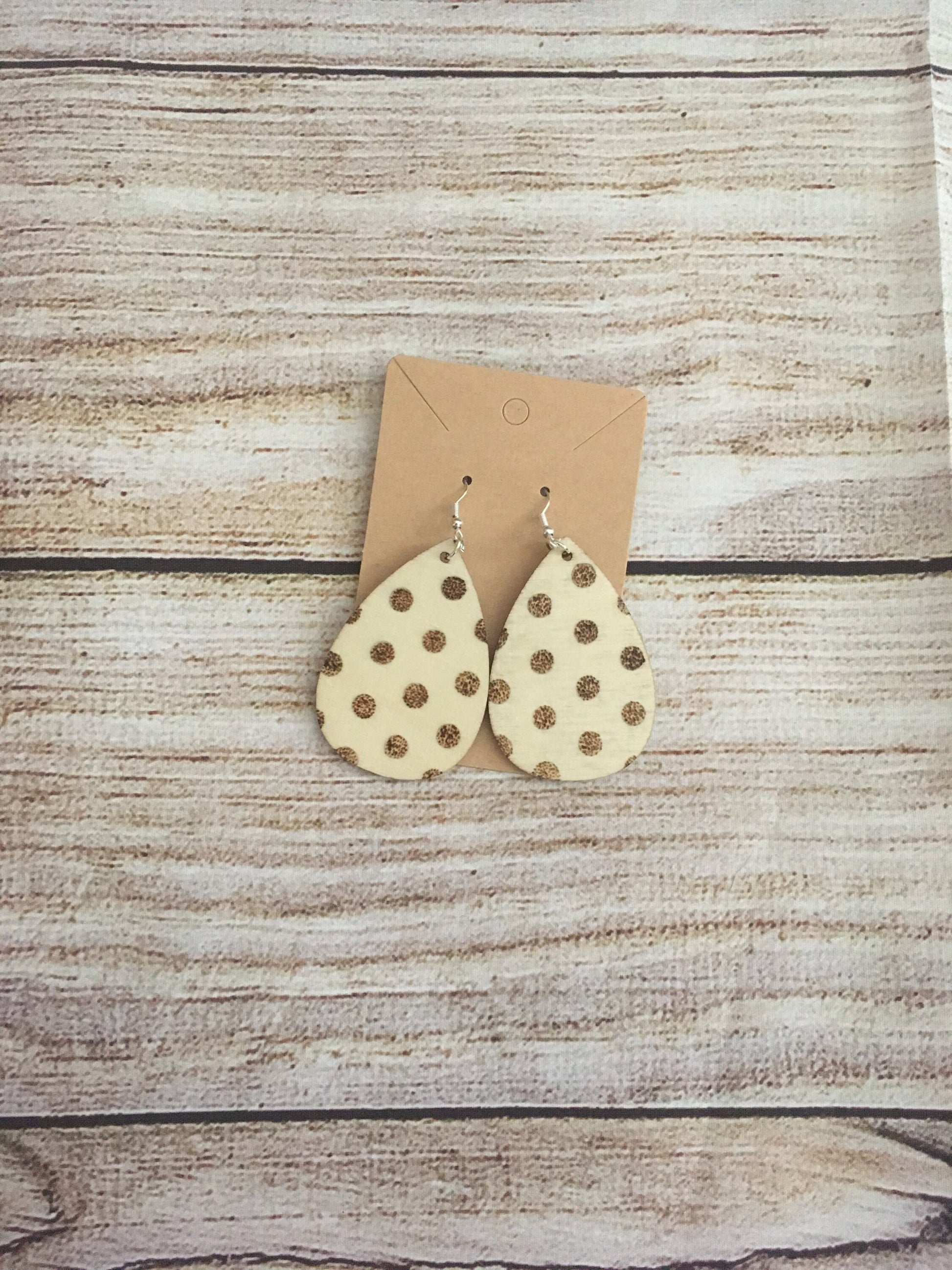 Wood burned earring with polka dot pattern. Earrings are tear drop shaped with fishhooks