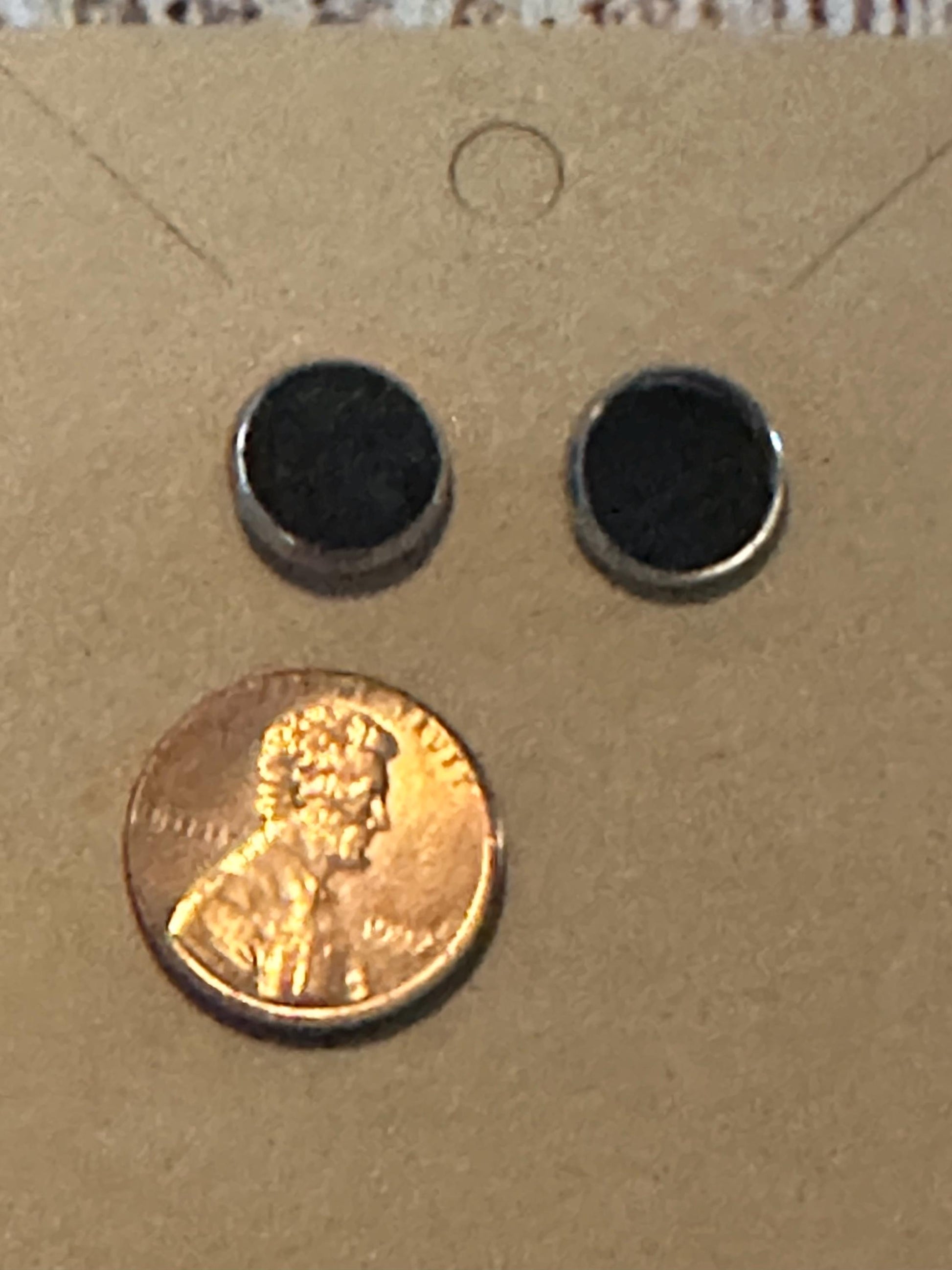 round stud earrings with black faux leather center with penny to show size